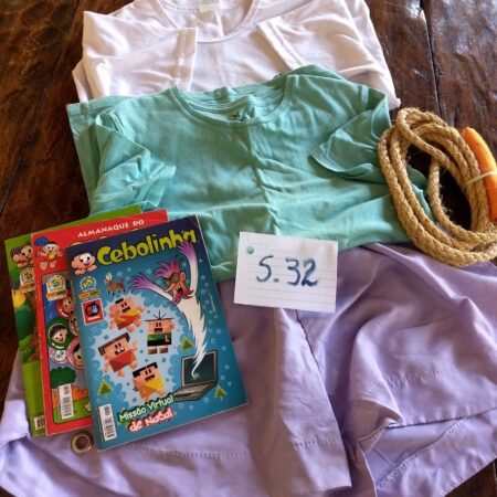 S-32: FEMININO: 2 blusas de manga curta, em malha; short de tactel; corda para pular; 3 revistas em quadrinhos