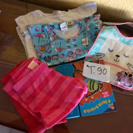 T-90: FEMININO: livro de estórias; babador; 1 par de meias; 2 calças compridas de malha;  camisa de malha estampada; camiseta estampada
