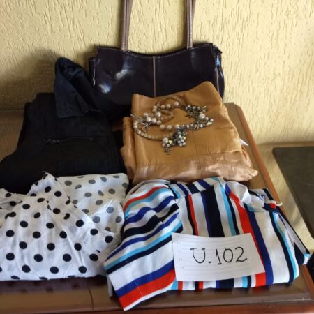 U-102: jaqueta ; blusa em tecido (manga comprida); vestido de festa (seda/verão); blusa (manga curta); bolsa de couro;